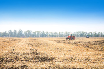Obraz premium Modern red tractor in the field.