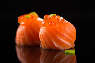 salmon sushi with caviar on the black background