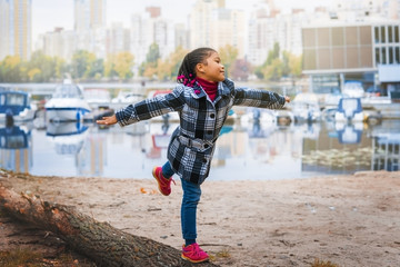 Naklejka premium The girl child walks near the river in the city autumn Park.