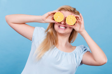 Girl covering her eyes with lemon citrus fruit