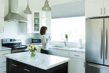 Woman Drinking Coffee in a Modern Kitchen