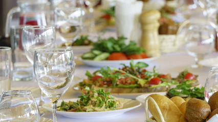 Served table for a banquet in a restaurant, in the foreground in focus is a basket with bread