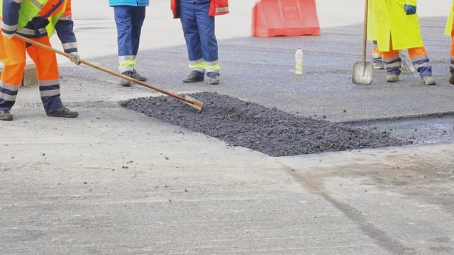Men lay asphalt on the road. Road re-construction.