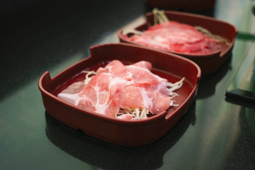 Raw fillet pork and beef sliced on red dish