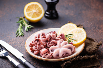 Baby octopus in plate with lemon and rosemary