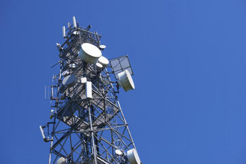 Telecommunication tower with antennas against the blue sky
