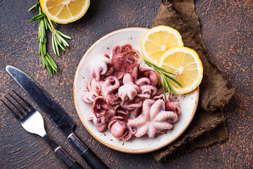 Baby octopus in plate with lemon and rosemary