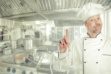 Cheerful male chef cook. Background - the kitchen.