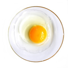 Whipping raw chicken egg with yolk on glass transparent plate. Isolated. White background. Top view