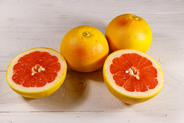 Ripe fresh grapefruits on white wooden table