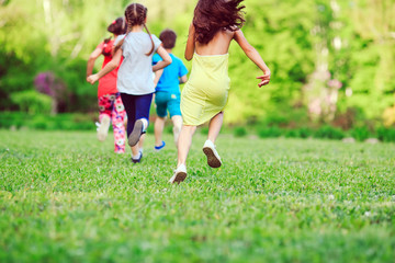 Fototapeta premium Many different kids, boys and girls running in the park on sunny summer day in casual clothes