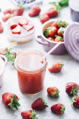 Frontal view of strawberry detox juice in w berries inside ceramic colored cocotte, blueberries, strawberries, raspberries, flat lay.Detox and healthy food concept.