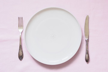 Table place setting on pink linen tablecloth. Top view. Concept.