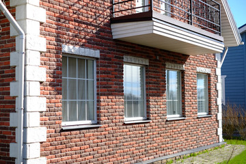 Walkway of old paving stones. New modern architectural building of the house. large panoramic Windows. Against the blue sky.