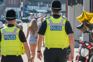 two policemen on the beat in the uk following a pretty girl with long legs and blonde hair