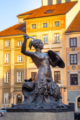 View of the bronze statue of Mermaid on the Old Town Market Square of Warsaw, surrounded by colorful old houses, Poland. © gatsi