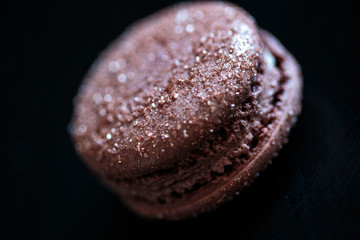 composition of macaroons on a black wooden table. Close up macro photo of colorful biscuits