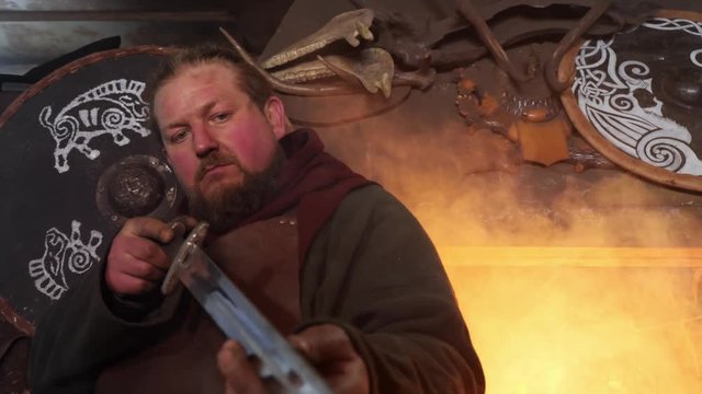 The medieval blacksmith taken sword to examine metal of sword
