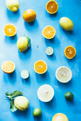 Summer fruit background, top view of summer fruit Assortment of citrus fruits on a blue background, top view,avocado,Oranges, grapefruit, tangerine, lime, lemon ,vegetarian healthy food concept.