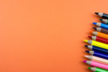 Pencils set on rose orange color paper. Empty space for text and design. Minimalism concept