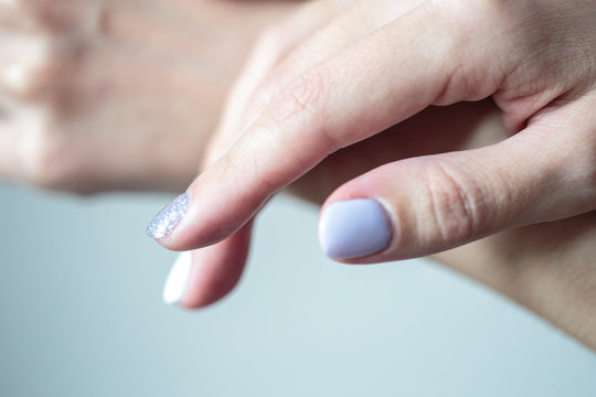 Gorgeous manicure, pastel tender color nail polish, closeup photo. Female hands over simple background