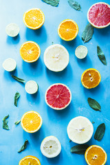 Assortment of citrus fruits on a blue background, top view. Oranges, grapefruit, tangerine, lime, lemon ,vegetarian healthy food concept.