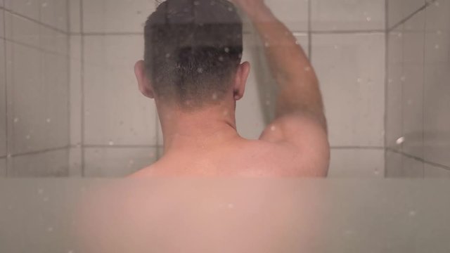 Young Handsome Man Comes Into The Shower To Wash Himself And Closes The Glass Door