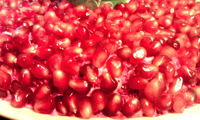 Red ripe pomegranate seeds on a plate.