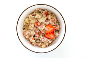 Bowl of healthy oatmeal with fresh strawberries for breakfast. Overhead shot.