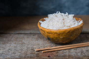 Bowl with white rice on the wooden background, wabi sabi style