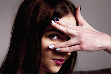 shy woman looking through fingers as a symbol of abuse and corruption in business