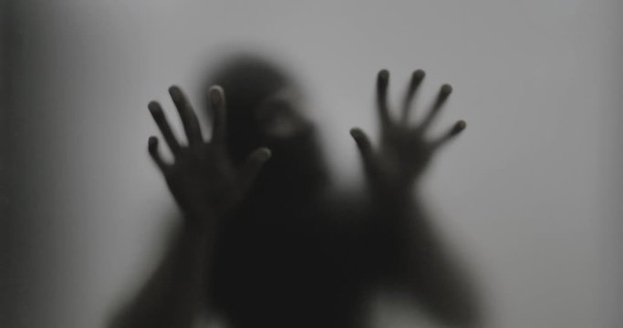 Shadowy figure behind glass / fear, panic concept