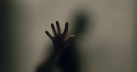 Shadowy figure behind glass / fear, panic concept