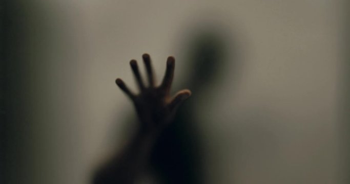 Shadowy figure behind glass / fear, panic concept