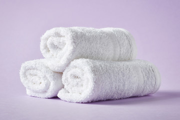 Fototapeta na wymiar White spa towels on purple background