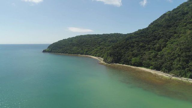 Aerial view of tropical beach in bay with turquoise water. Siwangag Cove. Coast of tropical island Palau with mountains covered rainforest. Santa Ana, province of Cagayan, Philippines.