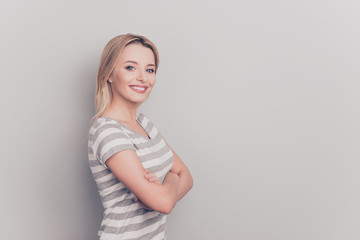 Hallf-turned profile side view portrait of cheerful confident excited smart pretty beautiful charming lady standing with crossed arms clothed in stripped tshirt isolated on gray background copyspace
