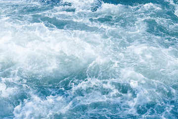 Fototapeta na wymiar Abstract blue background of foamy sea wave