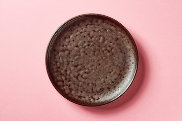 Brown plate on pink background, from above