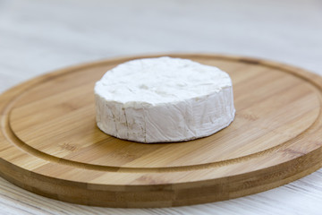 Camembert cheese or brie on  wooden board. Side view.