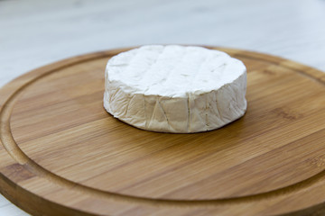 Camembert cheese or brie on  wooden board. Side view.
