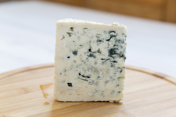 Blue cheese on wooden board. Side view. Closeup