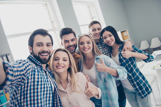 Self portrait of economists, students, financiers, lawyers in casual outfit showing thumb up with fingers shooting selfie on front camera with joyful cheerful expression having pause, break, hugging