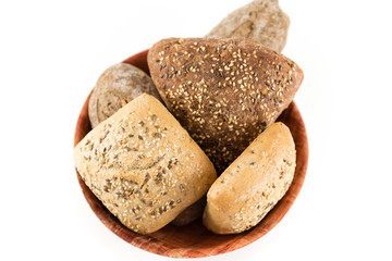 bread with cereals and nuts in a brown bowl on white background