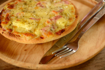  Pizza with fork and knife on wooden plate. Selective focus.