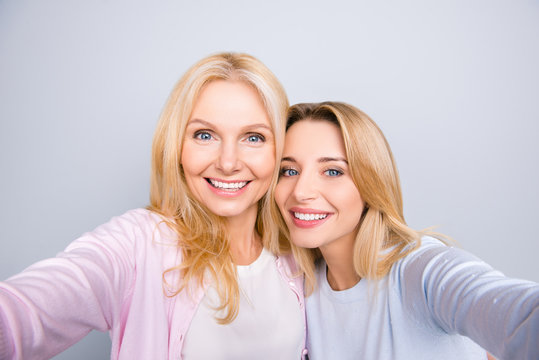 Self portrait of pretty charming cute trendy stylish attractive women shooting selfie on front camera having beaming smiles casual outfits isolated on grey background