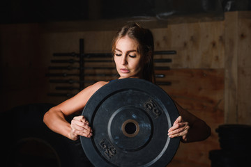 Fototapeta na wymiar Portrait of woman in gym with plate 5 kg