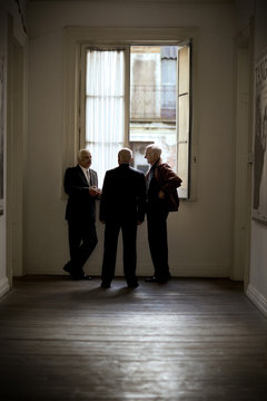 View of three men talking in a corner.
