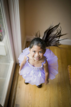 Smiling young girl wearing a purple tutu.