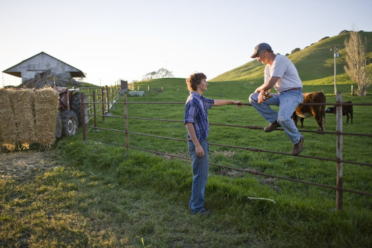 Man and his teenage son working on a farm